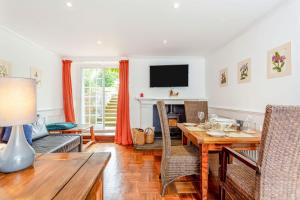 a living room with a table and chairs and a television at The Garden Flat Ardullie in Ardullie