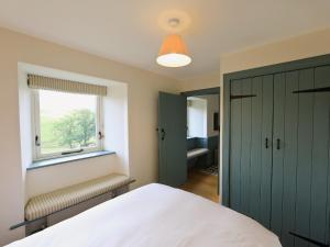 a bedroom with a white bed and a window at The Granary in Crocketford