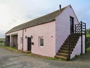 a pink building with a staircase on the side at The Granary in Crocketford