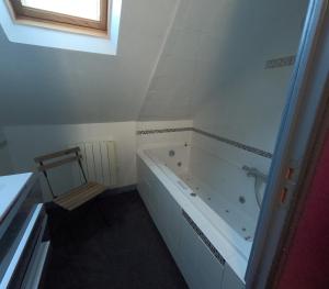 La salle de bains blanche est pourvue d'une baignoire et d'une fenêtre. dans l'établissement VIEUX LOGIS, à Vervins