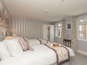 a bedroom with two beds and a table on top at Haddon Villa in Bakewell