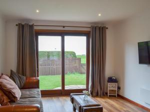 a living room with a couch and a large window at Beach View in Nairn