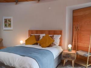 1 dormitorio con 1 cama con manta azul y almohadas amarillas en The Roondie, en Ladybank