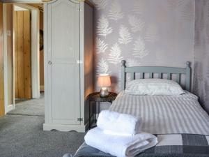 a bedroom with a bed with towels on it at Chapel Farm Cottage in Wetwang