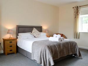 a bedroom with a bed with two towels on it at Liftingstane Cottage in Closeburn