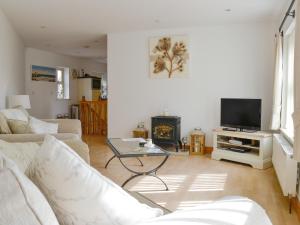 a living room with a couch and a tv at Mickle Hill Mews in Gargrave