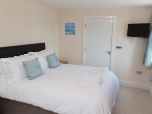 a bedroom with a white bed with towels on it at Apartment 5 Latitude 51 Westward Ho! in Westward Ho