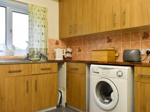 a kitchen with a washing machine and a sink at Penn Hill View in Aysgarth