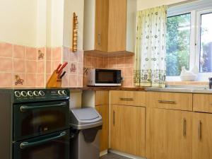 a kitchen with a stove and a microwave at Penn Hill View in Aysgarth