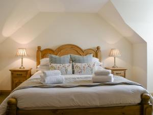 a bedroom with a bed with towels on it at Deuchars Cottage in Kenmore