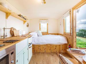 1 dormitorio con 1 cama y cocina con ventana en Woodside Hut 1 - Uk36105, en Auchterneed