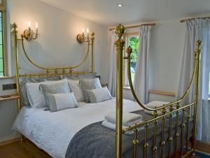a bedroom with a gold bed with white pillows at The Escape in South Hill