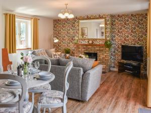 a living room with a couch and a fireplace at Hawks Mill Cottage in Needham Market
