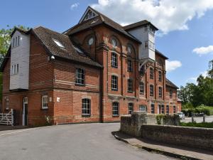 a large red brick building with a clock tower at Hawks Mill Cottage in Needham Market