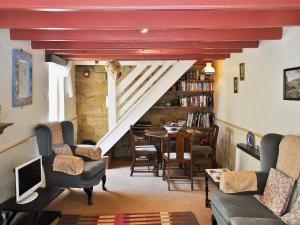 a living room with a staircase and a table and chairs at Felicity Cottage in Staithes