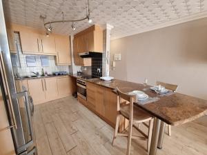 a kitchen with a wooden table and a counter top at Diaz Views 10 in Jeffreys Bay