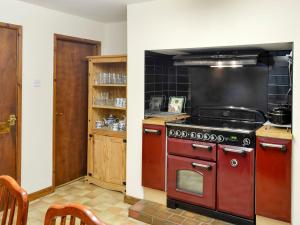 eine Küche mit einem roten Herd im Zimmer in der Unterkunft Cleiriach in Gwytherin