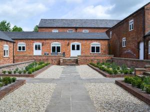 ein Backsteingebäude mit einem Garten davor in der Unterkunft Granary Lodge in binbrook