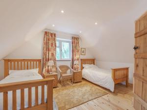 a bedroom with two beds and a window at The Grooms Quarters - Uk39053 in East Barkwith