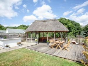 a gazebo with a table and chairs on a wooden deck at Sundance in Cheriton Bishop