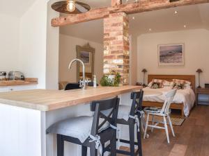 cocina con encimera grande y cama de fondo en The Old Dairy At Wooton - Ukc4355, en Plumpton Green