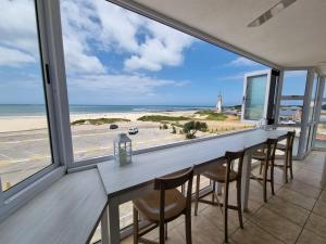 a dining room with a table and chairs and a view of the beach at Diaz Views 10 in Jeffreys Bay