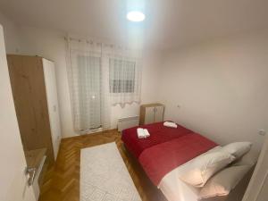 een slaapkamer met een bed met een rode deken bij Eleni in Vrnjačka Banja