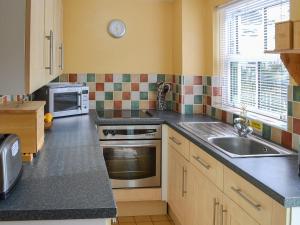 a kitchen with a sink and a stove at Willow Cottage in Newlyn East