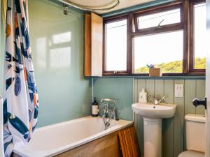 a bathroom with a tub and a sink and a toilet at Rosebank Cottage in Borgue