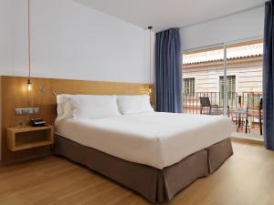 a bedroom with a large bed and a balcony at Hotel Saratoga in Palma de Mallorca