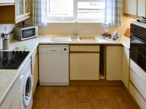 a small kitchen with a sink and a dishwasher at Rosemarys Sea View in Bacton