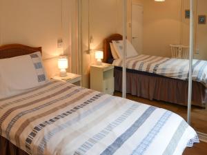 BactonにあるRosemarys Sea Viewの小さな部屋で、ベッド2台、ランプ2つが備わります。