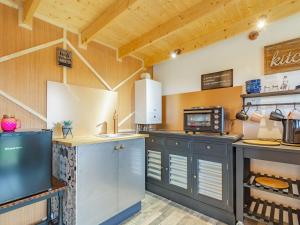 a large kitchen with wooden walls and wooden ceilings at Hollys Hidden Hideaway - Uk36783 in Sutton Valence