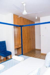 a room with two beds and a blue chair at 2 B/room Nyali City Mall W/Pool in Mombasa