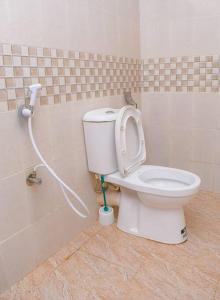 ein Bad mit einem WC und einem Schlauch in der Unterkunft 2 B/room Nyali City Mall W/Pool in Mombasa