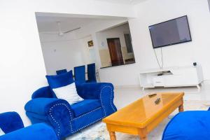 ein Wohnzimmer mit blauen Stühlen und einem Couchtisch in der Unterkunft 2 B/room Nyali City Mall W/Pool in Mombasa