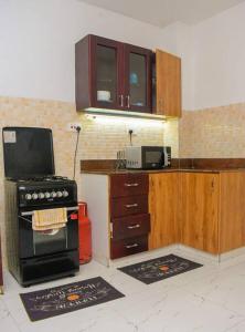 a kitchen with a stove and a microwave at 2 B/room Nyali City Mall W/Pool in Mombasa