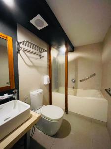 Villa Rosita Hotel في نجا: حمام مع مرحاض ومغسلة وحوض استحمام