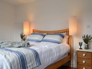 Cama con mantas y almohadas azules y blancas en Sea Breezes, en Totland