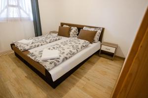 1 dormitorio con 1 cama grande y suelo de madera en Halfarock Üdülőház, en Levelek