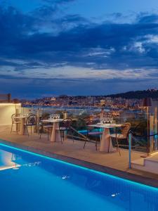a balcony with tables and chairs next to a swimming pool at Hotel Saratoga in Palma de Mallorca
