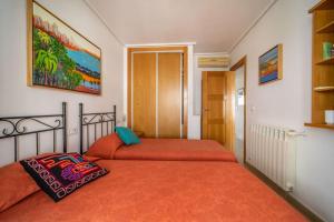 1 Schlafzimmer mit 2 Betten und orangefarbener Bettwäsche in der Unterkunft 2 Bed Flat/Apartment on La Torre Golf Resort in Torre-Pacheco