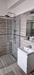 La salle de bains est pourvue d'une douche et d'un lavabo. dans l'établissement Hotel Triumf, à Bucarest