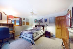 a bedroom with a bed and a desk and a chair at Ski Bike the East in Stowe