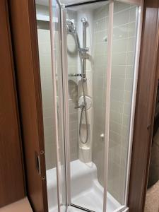 a shower with a glass door in a bathroom at Self Contained Holiday Home Caravan in Corsham +29 photos