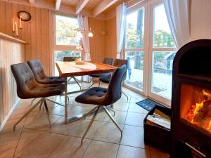 ein Esszimmer mit einem Tisch, Stühlen und einem Kamin in der Unterkunft Strandpark Baabe Haus 250 in Baabe
