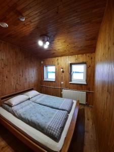 una camera da letto con un grande letto in una camera in legno di Kurzemes pērle a Sepene