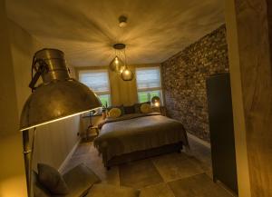 een slaapkamer met een bed en een bakstenen muur bij Gastenverblijf Bie Zus in Buggenum