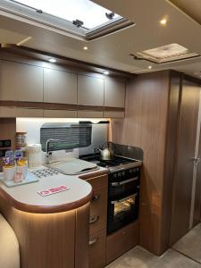 a kitchen with a stove and a counter top at Self Contained Holiday Home Caravan in Corsham