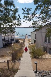 a person walking down a sidewalk next to the water at Ferienhäuser am Nordufer des Hainer Sees in Neukieritzsch